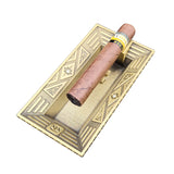 Art Deco metal cigar ashtray in gold finish with cigar on raised cigar rest