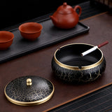 Black ceramic ashtray with gold accents