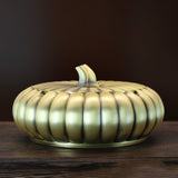 Metal ashtray with lid brass pumpkin design side view on wooden table