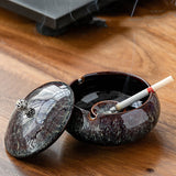 Black Plum Glaze ceramic ashtray with lid and cigarette rest on wooden table