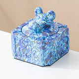 Blue swirl covered ceramic ashtray with sculpted ram head knob and vibrant marble pattern