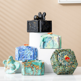 Assorted covered ceramic ashtrays with decorative lid knobs and marble-style patterns