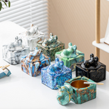 Decorative covered ceramic ashtrays displayed on table in assorted colors and knob styles