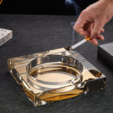 gold square crystal ashtray holding cigarette elegant design