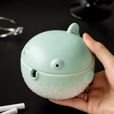 Close up of green pufferfish ashtray held in hand