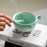 Side view of green ceramic pufferfish ashtray with cigarette rests