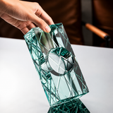 Hand holding Aqua Clear diamond-cut crystal glass cigar ashtray showing thick faceted design