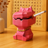 Pink dizzy hippo ceramic ashtray with cigarette on warm wooden table