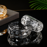 Clear faceted glass ashtray displayed with matching glass accessory