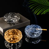 Clear amber and blue faceted glass ashtrays on black reflective surface