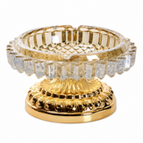 Champagne gold faceted glass ashtray with ornate gold metal stand on white background