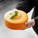 Orange ceramic ashtray with lid held in hand