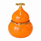 Orange gourd-shaped ceramic ashtray with lid and gold-tone trim on white background