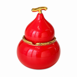 Red gourd-shaped ceramic ashtray with lid and gold-tone trim on white background
