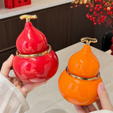 Red and orange gourd-shaped ceramic ashtrays showing covered lid and open bowl design