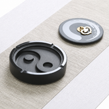 Black natural stone yin-yang ashtray with lid shown open 