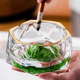 Green iceberg glass ashtray in hand with cigarette rest groove and sparkling color base