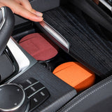 Maroon and orange lidded car ashtrays placed in a center console