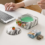 Covered ceramic ashtray with removable lid, cigarette rests and green marble-look finish on a desk