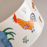 Close-up of colorful rooster pattern on glossy white ceramic ashtray