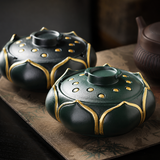 Teal and black lotus flower resin ashtrays with lids displayed on a dark tabletop