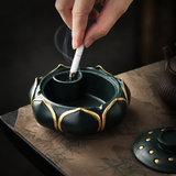 Open teal lotus flower ashtray being used with its removable lid beside it