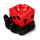 Red dice ceramic ashtray with black hand holder on white background