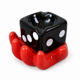 Black dice ceramic ashtray with red hand holder on white background