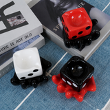Three glossy dice ceramic ashtrays on blue fabric and books