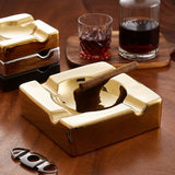 Gold luxury ceramic cigar ashtray with cigar on wooden tabletop