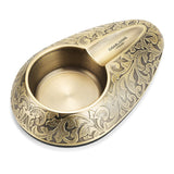 Vintage engraved alloy cigar ashtray in antique gold finish on white background