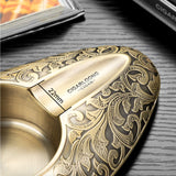Close-up of antique gold engraved cigar ashtray detail