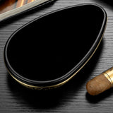 Bottom view of engraved alloy cigar ashtray showing smooth black base and oval shape