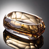 Angled close-up of champagne amber faceted crystal glass ashtray
