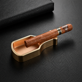 Metal cigar ashtray with cigar placed on built-in cigar rest, showing practical use for smoking setup