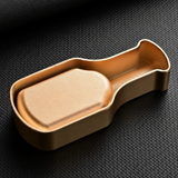 Bottom part of a champagne gold metal cigar ashtray on dark background with sleek modern finish