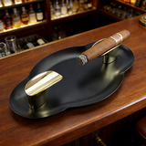 Matte black and gold stainless steel cigar ashtray with cigar on wooden bar counter