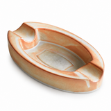 Rustic oval ceramic cigar ashtray with peach cream and gray unique glaze on white background