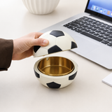 Hand opening soccer ball covered ashtray with gold removable metal tray on desk