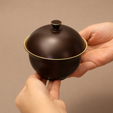 Dark bronze solid brass covered ashtray held in hand