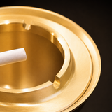 Close-up of gold brass ashtray rim with built-in cigarette rests