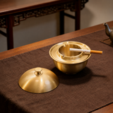 Gold brass ashtray with removable lid on tea table