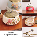 Close-up of vintage ceramic ashtray with removable lid and floral bird pattern