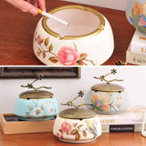 Decorative vintage ceramic ashtray with lid displayed on tabletop with floral bird pattern