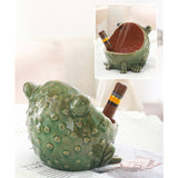 Green ceramic frog-shaped ashtray with a smaller inset showing it holding a cigar.