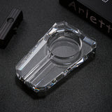Clear transparent smoke crystal glass cigar ashtray with double cigar rests on dark tabletop