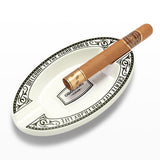 White oval resin cigar ashtray with cigar on white background