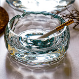 Top view of round crystal glass ashtray with turquoise base and cigarette