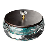 Angled view of round crystal glass ashtray with wooden lid