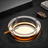 Gold crystal glass ashtray with cigarette on dark tabletop